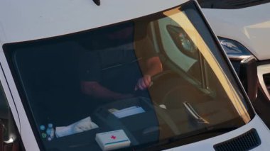 Chisinau, Moldova - 28 Eylül 2025: Beyaz bir minibüsün direksiyonunda oturan bir adam, ön camdan bakıldı