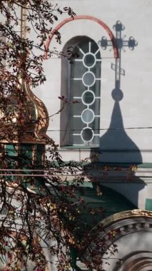 Güzel bir mimari detay dairesel pencereli bir duvara yansıtılan kilise haçının gölgesini gösteriyor. Dikey