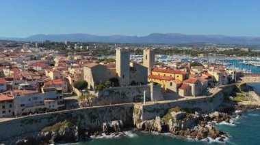 Picasso Müzesi 'nin ve Antibes marinasına bakan ortaçağ taş surlarının insansız hava aracı görüntüsü, yatlar kenetlenmiş ve Old Town' un teras çatıları...
