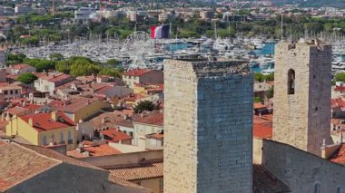 Picasso Müzesi 'nin ortaçağ taş kuleleri, yat ve yelkenlilerle dolu Antibes marinasına bakan insansız hava aracı görüntüsü.