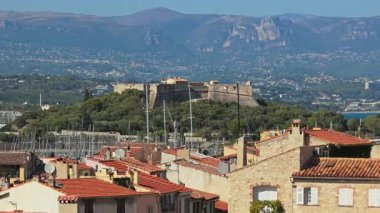 Antibes, Fransa - 4 Eylül 2025: 16. yüzyıl kalesi Carre Kalesi 'nin havadan insansız hava aracı görüntüsü, marinada yelkenliler ve arka planda dağlar