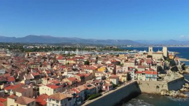 Ortaçağ surları, terracotta çatıları, marinası ve çevresindeki dağlarla Antibes Eski Kasabası 'nın insansız hava aracı görüntüsü.