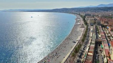 Nice 'deki Melekler Körfezi' nin hava aracı görüntüsü, Promenade des Anglais, Turkuaz Akdeniz suları ve uzaktaki deniz paraşütçüleri.