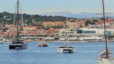 Palais des Festivals ve Cannes şehrinin arka planında gökyüzü olan lüks yatların insansız hava aracı görüntüsü.