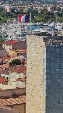 Picasso Müzesi 'nin ortaçağ taş kuleleri, yat ve yelkenlilerle dolu Antibes marinasına bakan insansız hava aracı görüntüsü. Dikey