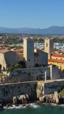 Picasso Müzesi 'nin hava aracı görüntüsü ve Antibes marinasına bakan ortaçağ taş surları, yatlar kenetlenmiş ve Old Town' un teras çatıları. Dikey