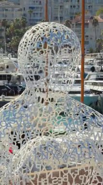 Antibes, Fransa - 4 Eylül 2025: Antibes 'te Jaume Plensa' nın Nomade heykelinin havadan drone görüntüsü, arka planda yatlar ve lüks tekneler. Dikey