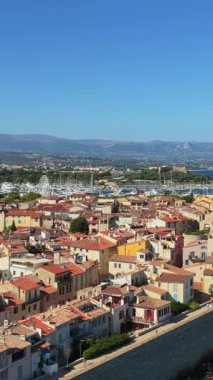 Ortaçağ surları, terracotta çatıları, marinası ve çevresindeki dağlarla Antibes Eski Kasabası 'nın insansız hava aracı görüntüsü. Dikey