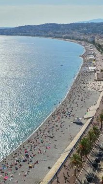 Nice 'deki Melekler Körfezi' nin hava aracı görüntüsü, Promenade des Anglais, Akdeniz suları turkuaz, ve uzaktan deniz paraşütçüleri. Dikey