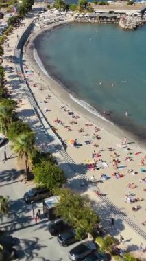 Nice 'in kumlu kumsal manzarası güneşlenenlerle ve yüzücülerle dolu palmiye çizgili Promenade des Anglais ve deniz kenarındaki binalarla dolu. Dikey