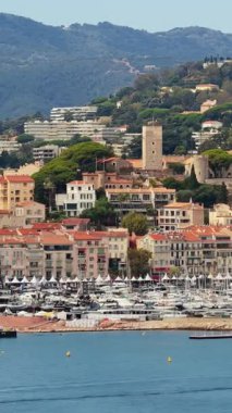 Tarihi kulesi, renkli çatıları ve marinasında lüks yatları olan Cannes Eski Şehir Le Suquet 'in insansız hava aracı görüntüsü. Dikey