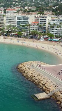 Cannes, Fransa - 6 Eylül 2025: Turkuaz su ve eğimli kıyı şeridi ile kumlu sahilin hava aracı görüntüsü. Dikey