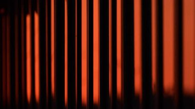 Benzersiz dikey çizgiler gün batımında kentsel ışıkta güzel turuncu desenler oluşturuyor. pencere yansıması