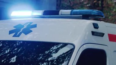 Chisinau, Moldova - 1 Ekim 2025: Alacakaranlıkta parlayan mavi ışıklarla bir şehir caddesinden geçen acil ambulans