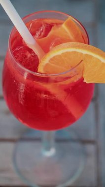 Cannes 'da güneşli bir günde serinletici bir Aperol Spritz kokteylini portakal dilimi ve buz küpleriyle kapatıyoruz. Dikey