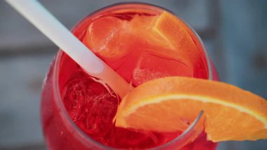 Serinletici bir Aperol Spritz kokteylini portakal dilimi ve buzla kapatıyoruz. Güneşli bir günde Cannes 'da açık havada çekiyoruz.