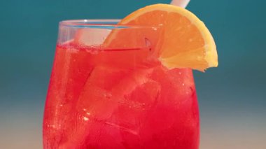 Serinletici bir Aperol Spritz kokteylini portakal dilimi ve buzla kapatıyoruz. Güneşli bir günde Cannes 'da açık havada çekiyoruz.