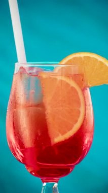 Portakal dilimi ve buz küplerini yoğunlaştırılmış bir bardak Aperol Spritz 'e koy. Dikey