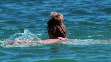 Fransa, Cannes yakınlarındaki Akdeniz 'in berrak mavi sularında tek başına yüzen bir kadın.