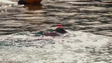 Bir kadın okyanusta şnorkelle yüzüyor, yumuşak güneş ışığı altında yumuşak sularda yüzüyor.