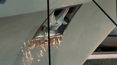 Cannes Marina 'da öğleden sonra güneşinin altında parlayan bir yatın metal çapasının detaylı bir görüntüsü.