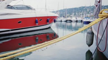 Modern kırmızı ve beyaz yat berrak yansımalarla sakin marina sularına kenetlendi.