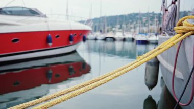 Modern kırmızı ve beyaz yat berrak yansımalarla sakin marina sularına kenetlendi.