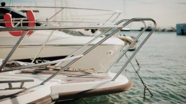 Krom korkuluklara ve lüks bir yatın ahşap güvertesine yakın altın ışığın altında limana yanaşmış.