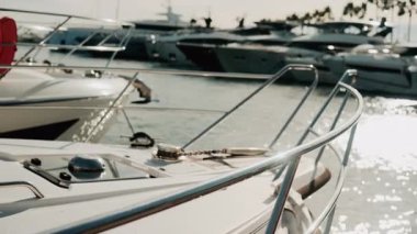 Krom korkuluklara ve lüks bir yatın ahşap güvertesine yakın altın ışığın altında limana yanaşmış.