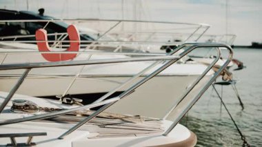 Krom korkuluklara ve lüks bir yatın ahşap güvertesine yakın altın ışığın altında limana yanaşmış.