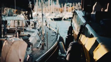 Altın saat boyunca yan yana rıhtıma yanaşmış yat ve yelkenlilerin yakın görüntüsü