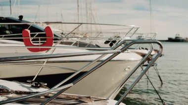 Krom korkuluklara ve lüks bir yatın ahşap güvertesine yakın altın ışığın altında limana yanaşmış.