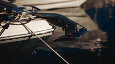 Limana yanaşmış lüks bir teknede iplerle cilalanmış bir krom çapa.