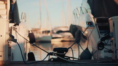 Durgun suda güneş ışığını yansıtan beyaz bir yatın yakınında.