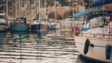 Altın saat boyunca yat limanında dizilmiş zarif yelkenliler, akşam güneşini yansıtan sakin sular.