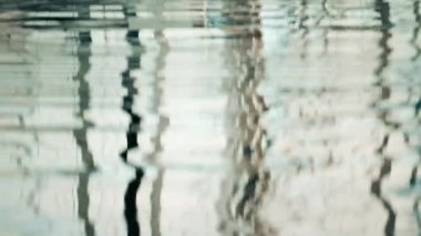 Suyun üzerinde dalgalanan gemi ve direklerin yansımaları.