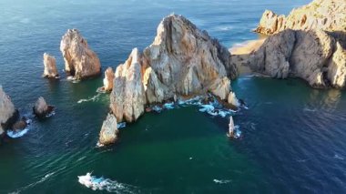 Cabo San Lucas 'taki Land' s End etrafındaki dramatik kayalık oluşumların ve turkuaz suların insansız hava aracı görüntüsü.