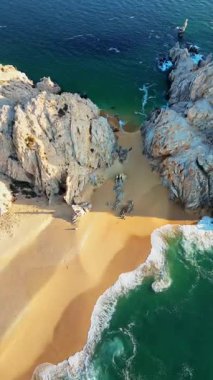 Cabo San Lucas 'ın en ünlü plajlarından biri olan Aşıklar Kumsalı' nın hava aracı görüntüsü. Heybetli kaya kayalıkları ve zümrüt sularıyla çerçevelenmiş. Dikey
