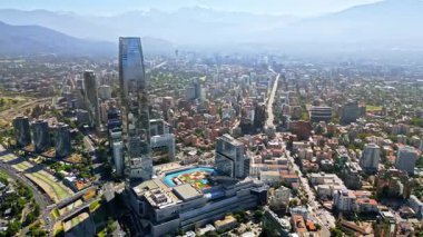 Santiago 'nun finans bölgesi üzerinde hava aracı görüntüsü Costanera Merkezi ve açık bir günde yeşil alanlar