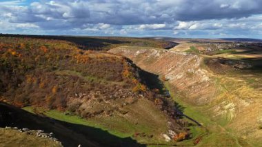 Moldova 'nın tepelik kanyon manzarasının sonbahar ağaçları ve dolambaçlı patikalarla hava aracı görüntüsü