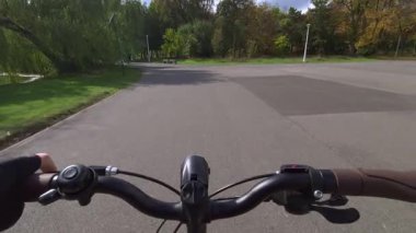 Cannes, Fransa - 5 Kasım 2025: Ağaçlar ve çalılarla kaplı göl yolu boyunca bisiklet süren ilk kişi görüntüsü