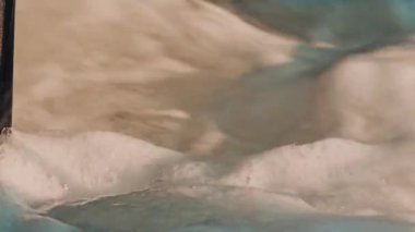 Hareket eden suda dönen kalın beyaz köpüğü kapat, yumuşak desenli görsel bir şekil oluştur.