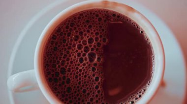 Köpüklü baloncuklarla kaplı sıcak bir fincan çikolatanın tepesinden aşağı.