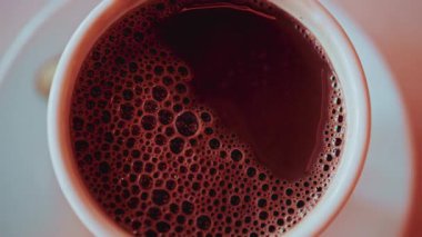 Köpüklü baloncuklarla kaplı sıcak bir fincan çikolatanın tepesinden aşağı.