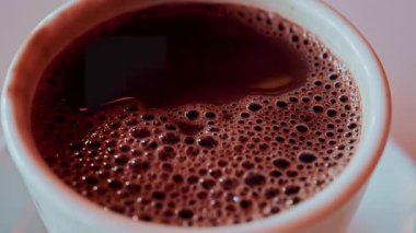 Köpüklü baloncuklarla kaplı sıcak bir fincan çikolatanın tepesinden aşağı.