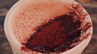 Sıcak çikolata ya da kakao tozu serpiştirilmiş kahve yüzeyine yakın.