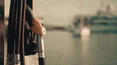 Vallauris, Fransa - 12 Kasım 2025: Bir marinadaki cilalı metal yakıt istasyonuna asılmış dizel yakıt hortumunun yakın çekimi