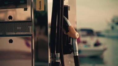 Vallauris, Fransa - 12 Kasım 2025: Bir marinadaki cilalı metal yakıt istasyonuna asılmış dizel yakıt hortumunun yakın çekimi