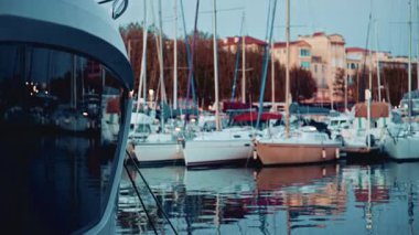 Yat yayı ön planda marina ve botlar mavi saatte arka planda.