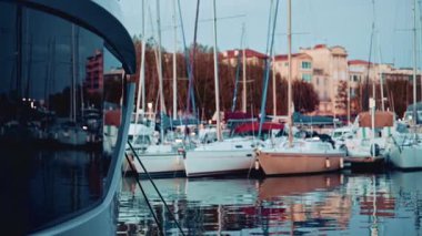 Yat yayı ön planda marina ve botlar mavi saatte arka planda.